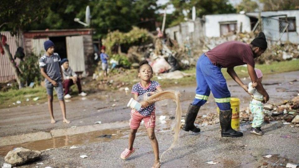  A child helps clearing water from an area damaged by floods in Uitenhage on June 05, 2024. Flooding caused by torrential rain and fierce winds on South Africa's eastern coast have killed at least 22 people, local authorities said on Tuesday. Flooding hit several locations in two eastern provinces, two rare tornados were spotted, temperatures plunged and snow fell in some central regions.