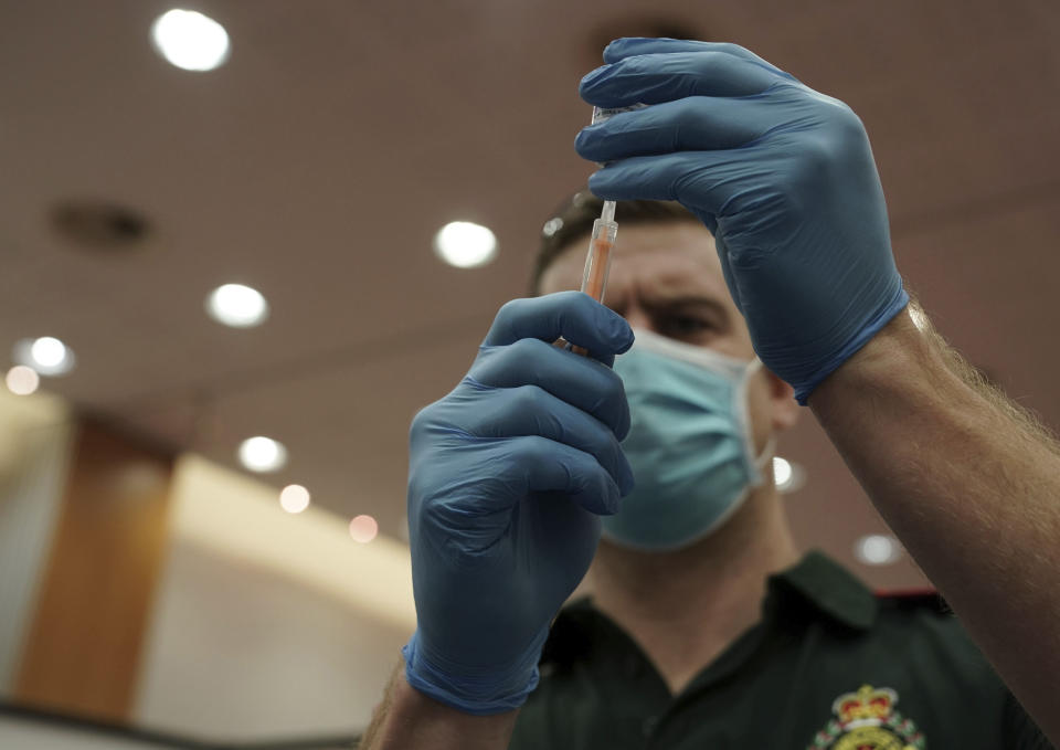 A healthcare worker fills a syringe with the Oxford/AstraZeneca Covid-19 vaccine at the vaccine centre that has been set up in central Newcastle, Scotland Monday Jan. 11, 2021. The centre is one of the seven mass vaccination centres now opened as the government continues to ramp up the coronavirus vaccination programme. (Owen Humphreys/PA via AP)