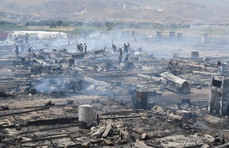 Civil defence members and civilians put out fire at a camp for Syrian refugees near the town of Qab Elias, in Lebanon's Bekaa Valley, July 2, 2017. REUTERS/Hassan Abdallah