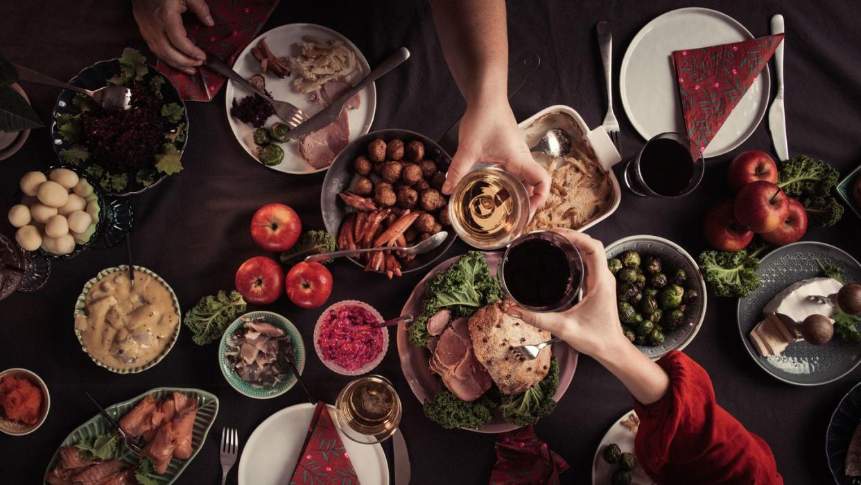 two people toasting over dinner table