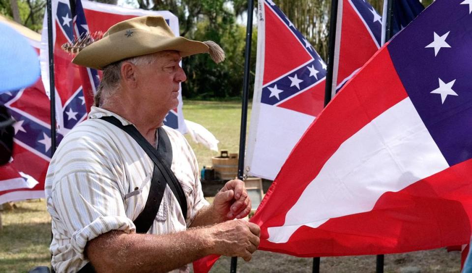 A historical reenactor gives a presentation of Civil War era flags during a public event hosted by the United Daughters of the Confederacy and Florida State Parks at Gamble Plantation Historic State Park.