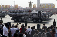 Military vehicles roll down as members of a Chinese military honor guard march during the parade to commemorate the 70th anniversary of the founding of Communist China in Beijing, Tuesday, Oct. 1, 2019. (AP Photo/Ng Han Guan)