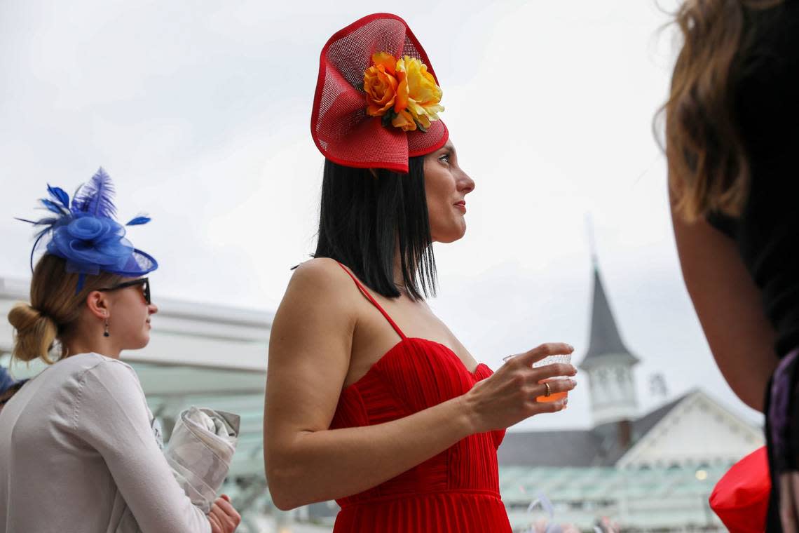 Wearing bright red, Shea Leparoux watches an early race featuring her husband, jockey Julien Leparoux, during Kentucky Derby 150 at Churchill Downs in Louisville, Ky., Saturday, May 4, 2024. Amy Wallot