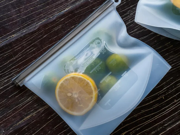 Clear, reusable bag with fresh lemons and limes