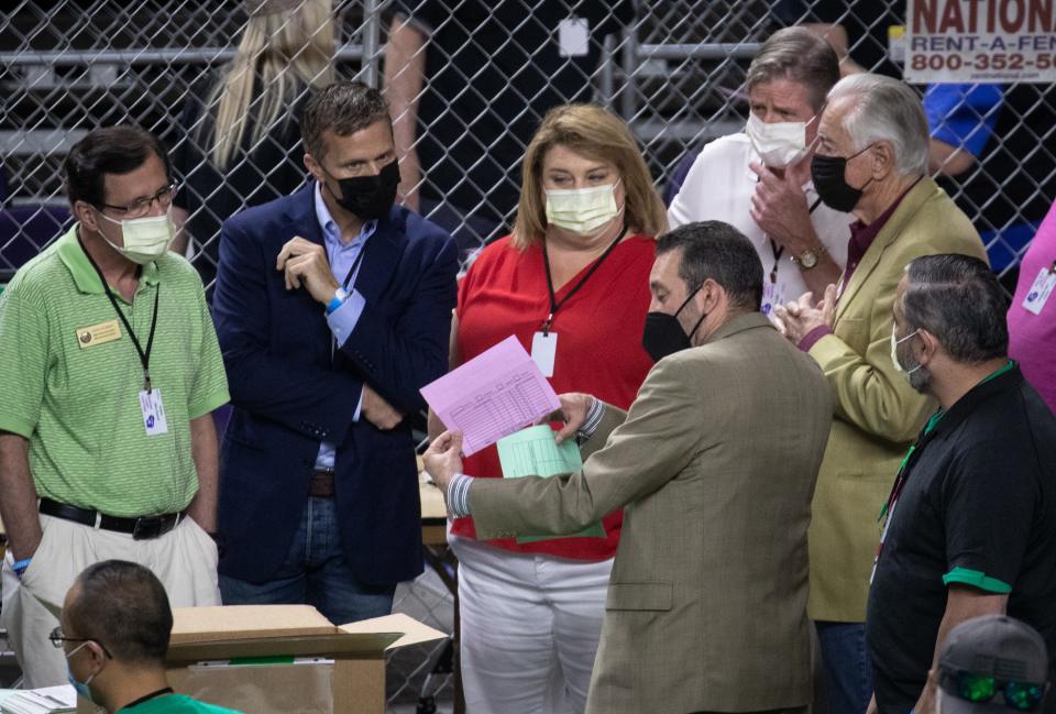 Wisconsin State Representative Janel Brandtjen (center), Eric Greitens (2nd from left) and Wisconsin State Representative Dave Murphy (left) watch as Maricopa County ballots from the 2020 general election are examined and recounted by contractors hired by the Arizona Senate on June 12, 2021, at Arizona Veterans Memorial Coliseum in Phoenix, Ariz.