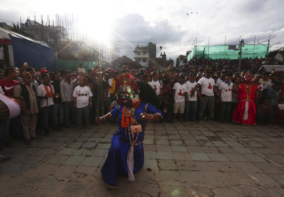 Masked dancers perform a traditional during Indra Jatra festival, an eight-day festival that honors Indra, the Hindu god of rain, in Kathmandu, Nepal, Friday, Sept. 13, 2019. The girl child revered as the Living Goddess Kumari is pulled around Kathmandu in a wooden chariot, families gather for feasts and at shrines to light incense for the dead, and men and boys in colorful masks and gowns representing Hindu deities dance to the beat of traditional music and devotees' drums, drawing tens of thousands of spectators to the city's old streets. (AP Photo/Niranjan Shrestha)