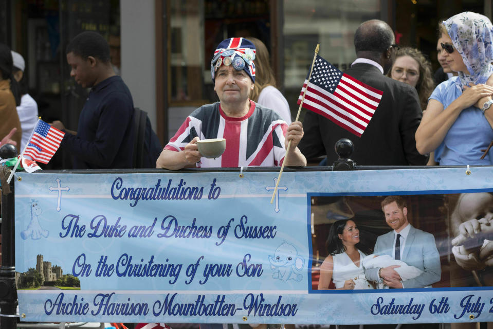 Royal superfan John Loughrey holds a sign in celebration of the royal christening of Archie, the son of Britain's Prince Harry and Meghan, Duchess of Sussex, outside Windsor Castle in England, Saturday, July 6, 2019. The 2-month-old son of the Duke and Duchess of Sussex will be baptized Saturday in a private chapel at the castle by Archbishop of Canterbury Justin Welby, head of the Church of England. (Rick Findler/PA via AP)