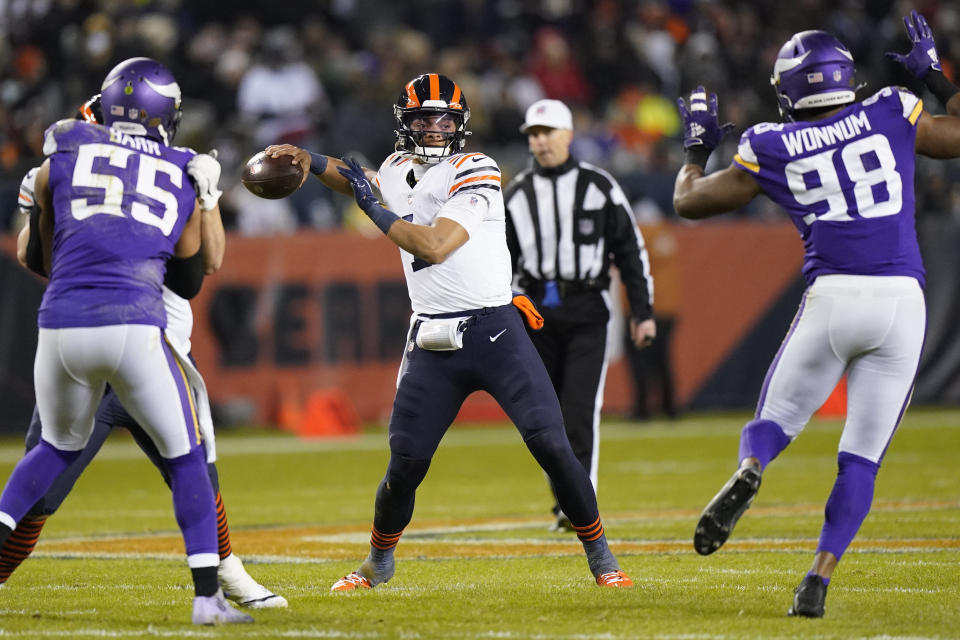 Chicago Bears quarterback Justin Fields (1) passes between Minnesota Vikings outside linebacker Anthony Barr (55) and defensive end D.J. Wonnum during the first half of an NFL football game Monday, Dec. 20, 2021, in Chicago. (AP Photo/Nam Y. Huh)