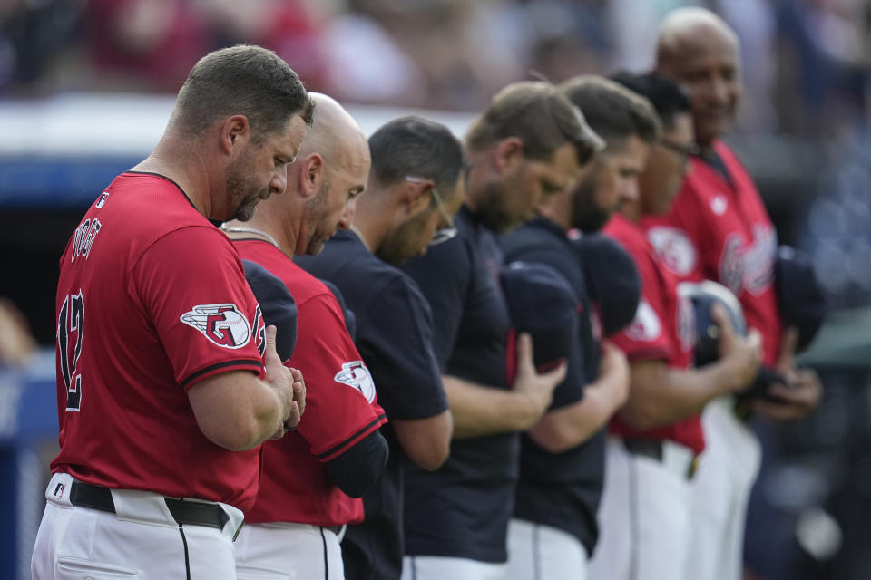 Cleveland Guardians manager Stephen Vogt, left, and others stand for a moment of silence in tribute to Willie Mays, who died Tuesday, before a baseball game between the Seattle Mariners and the Guardians, Wednesday, June 19, 2024, in Cleveland. (AP Photo/Sue Ogrocki)