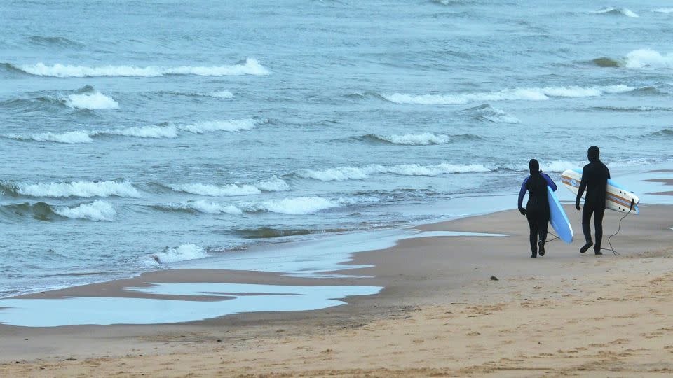 A pair of surfers take advantage of mild temperatures as they scout conditions along Lake Michigan on Dec. 28, 2023, in St. Joseph, Michigan. - Don Campbell /The Herald-Palladium/AP