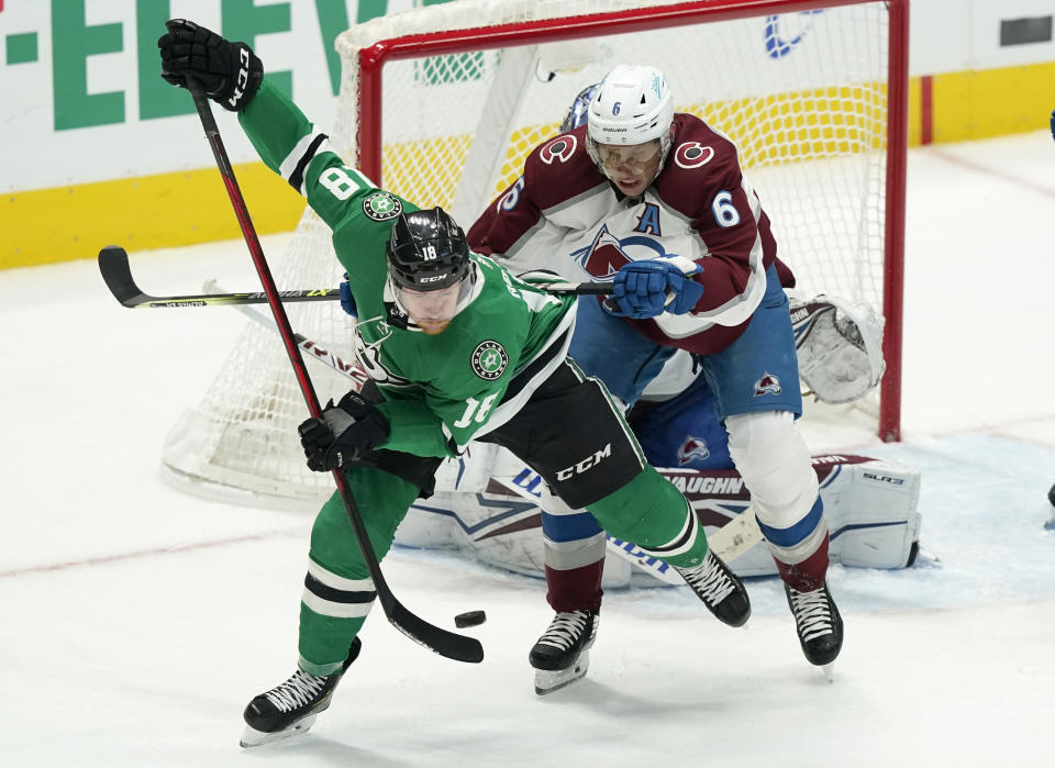 Colorado Avalanche defenseman Erik Johnson (6) and Dallas Stars left wing Michael Raffl (18) tangle in front of the goal during the first period of an NHL hockey game in Dallas, Friday, Nov. 26, 2021. (AP Photo/LM Otero)