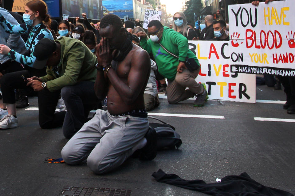 SYDNEY, AUSTRALIA - JUNE 06: A protester kneels during a 'Black Lives Matter' protest march on June 06, 2020 in Sydney, Australia. Events across Australia have been organised in solidarity with protests in the United States following the killing of an unarmed black man George Floyd at the hands of a police officer in Minneapolis, Minnesota and to rally against aboriginal deaths in custody in Australia. (Photo by Lisa Maree Williams/Getty Images)