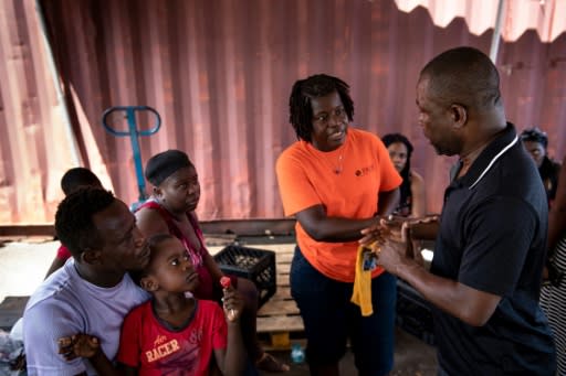 Haiti's charge d'affaires Dorval Darlier (R) talks to survivors of Hurricane Dorian