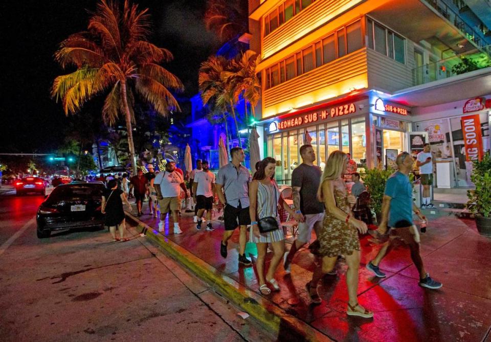 People walk Ocean Drive during the first day of Memorial Day Weekend in Miami Beach, Florida, on Friday, May 27, 2022.