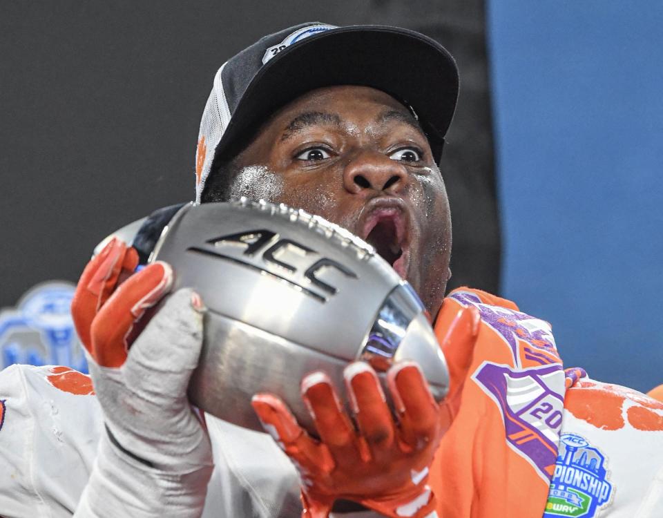 Clemson defensive tackle Ruke Orhorhoro (33) raises the ACC Championship trophy near team players after the game over  North Carolina in the ACC Championship football gameat Bank of America Stadium in Charlotte, North Carolina Saturday, Dec 3, 2022. Clemson won 39-10.