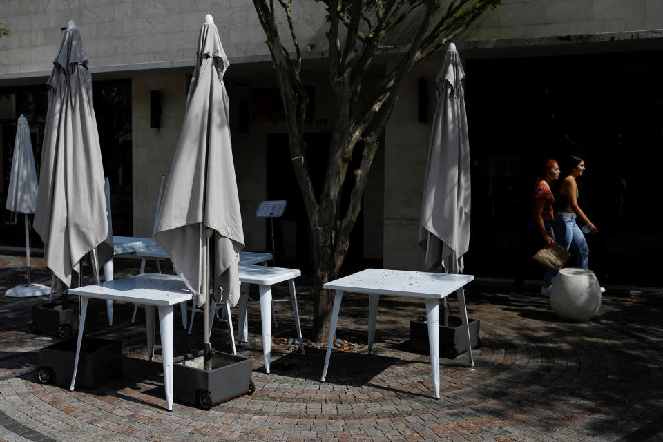 Image: Women walk past empty tables outside a restaurant, as Miami-Dade County eases some of the lockdown measures put in place during the coronavirus disease (COVID-19) outbreak, in Miami (Marco Bello / Reuters)