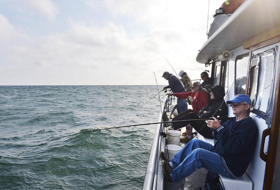 Joe Lawson, 64, front right, of Erie, fishes for perch on Lake Erie as he and about a dozen other fishermen try their luck aboard a perch fishing trip aboard the "O Danny O" charter boat in this file photo taken on June 28, 2015.