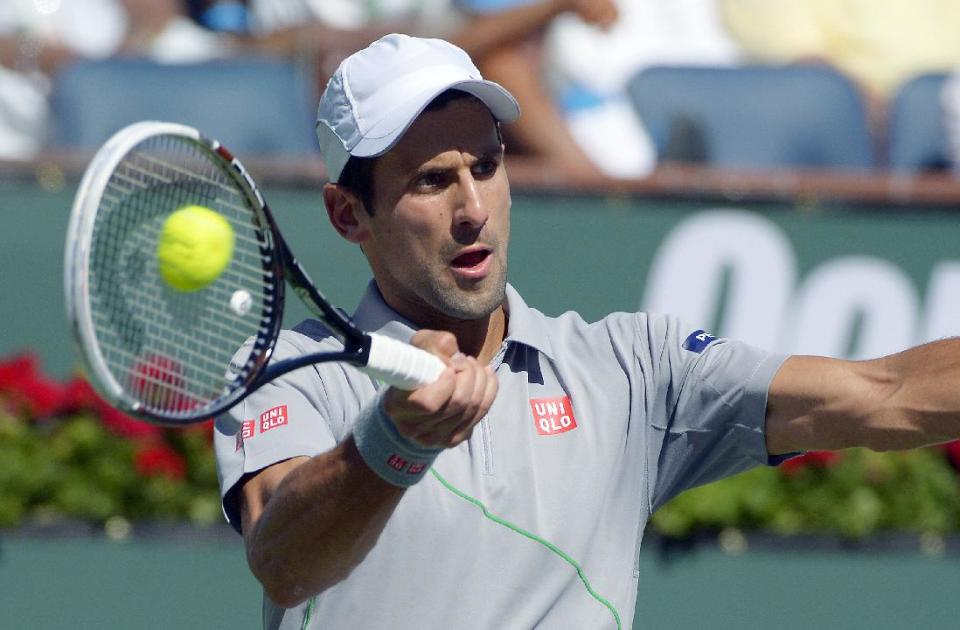 Novak Djokovic, of Serbia, hits a shot from Roger Federer, of Switzerland, in the final match of the BNP Paribas Open tennis tournament, Sunday, March 16, 2014, in Indian Wells, Calif. (AP Photo/Mark J. Terrill)