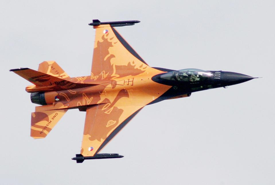 an orange fighter jet mid-flight