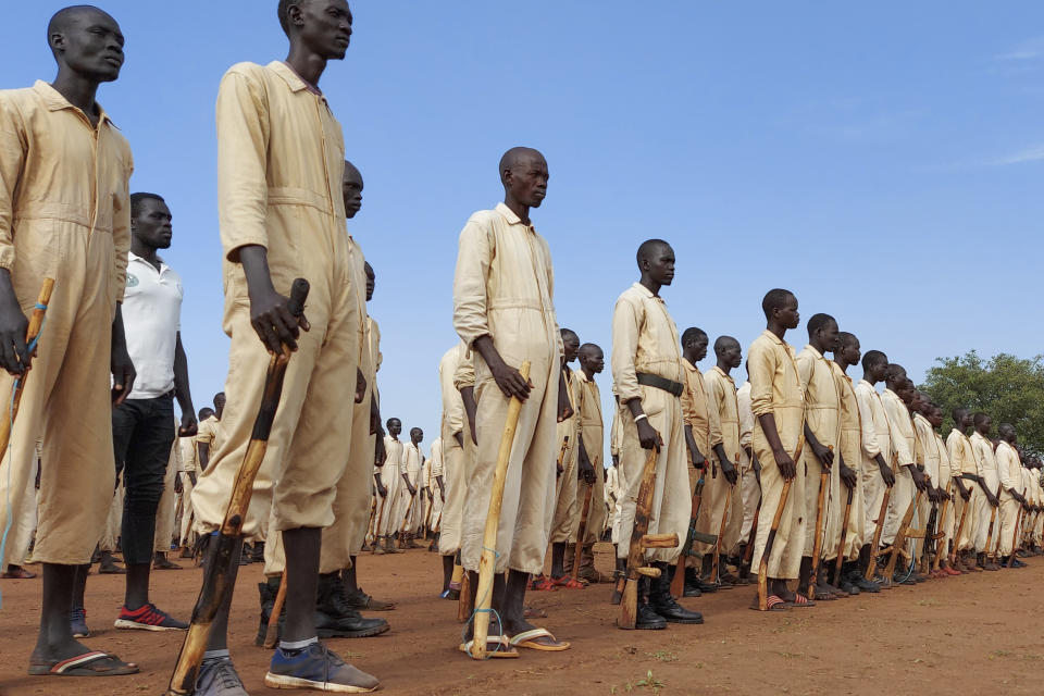 Trainees parade with the wooden mock guns which they use to train with, during the visit of the defense minister to a military training center in Owiny Ki-Bul, Eastern Equatoria, South Sudan Saturday, June 27, 2020. At crowded camps in South Sudan, former enemies are meant to be joining forces and training as a unified security force after a five-year civil war so they can help the shattered country recover but they can barely find enough food. (AP Photo/Maura Ajak)