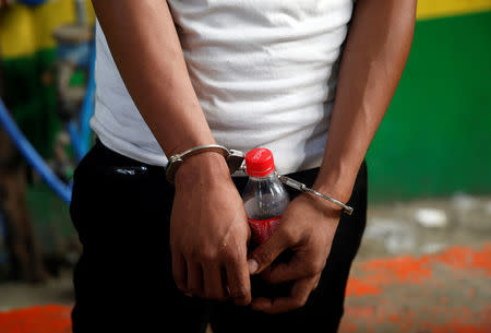 A man who was detained because of a pending criminal court case, is pictured holding a soda bottle while handcuffed, during an anti-drugs operation in Mandaluyong, Metro Manila in the Philippines, November 10, 2016. REUTERS/Erik De Castro