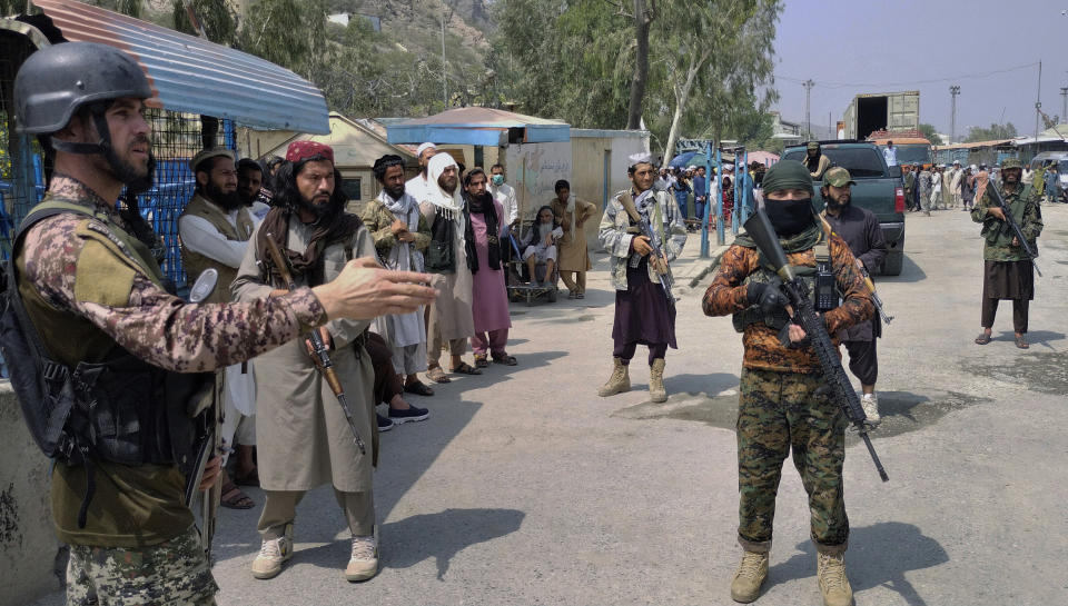 FILE - A Pakistani paramilitary soldier, left, and Taliban fighters stand guard on their respective sides, at a border crossing point between Pakistan and Afghanistan, in Torkham, in Khyber district, Pakistan, on Sept. 5, 2021. The main crossing on the Afghan-Pakistan border remained shut Tuesday, Feb. 21, 2023, for the third straight day, officials said, after Afghanistan's Taliban rulers earlier this week closed the key trade route and exchanged fire with Pakistani border guards. (AP Photo/Qazi Rauf, File)