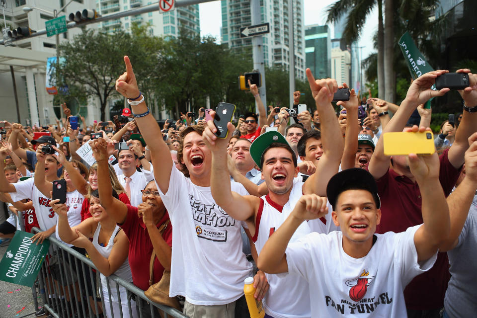 MIAMI, FL - JUNE 25: Fans cheer as Miami Heat players pass by in a victory parade through the streets during a celebration for the 2012 NBA Champion Miami Heat on June 25, 2012 in Miami, Florida. The Heat beat the Oklahoma Thunder to win the NBA title. (Photo by Joe Raedle/Getty Images)