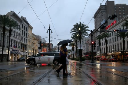 A couple walks across Canal St. during Hurricane Barry in New Orleans