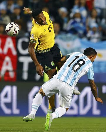 Jamaica's Jermaine Taylor and Argentina's Carlos Tevez (18) jump for the ball during their first round Copa America 2015 soccer match at Estadio Sausalito in Vina del Mar, Chile, June 20, 2015. REUTERS/Ivan Alvarado