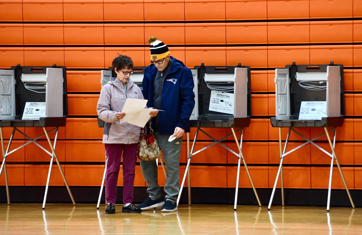 Helen Aromando and her son Rudolf study their ballots at North High School Tuesday morning.