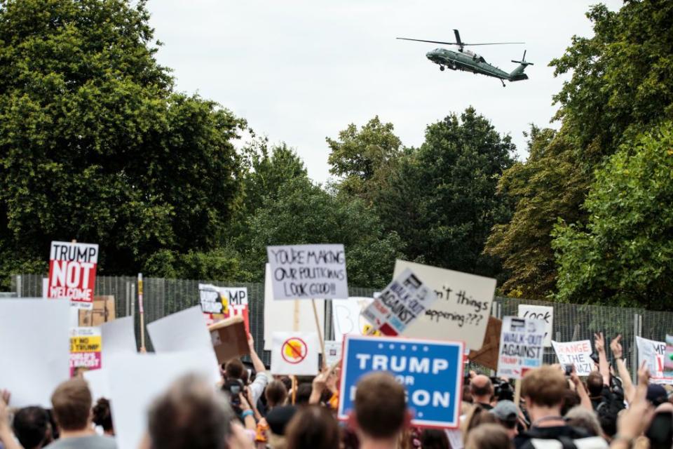 <p>Activists protest outside the London residence of US ambassador Woody Johnson as Marine One arrives at to pick up the President and First Lady.</p>