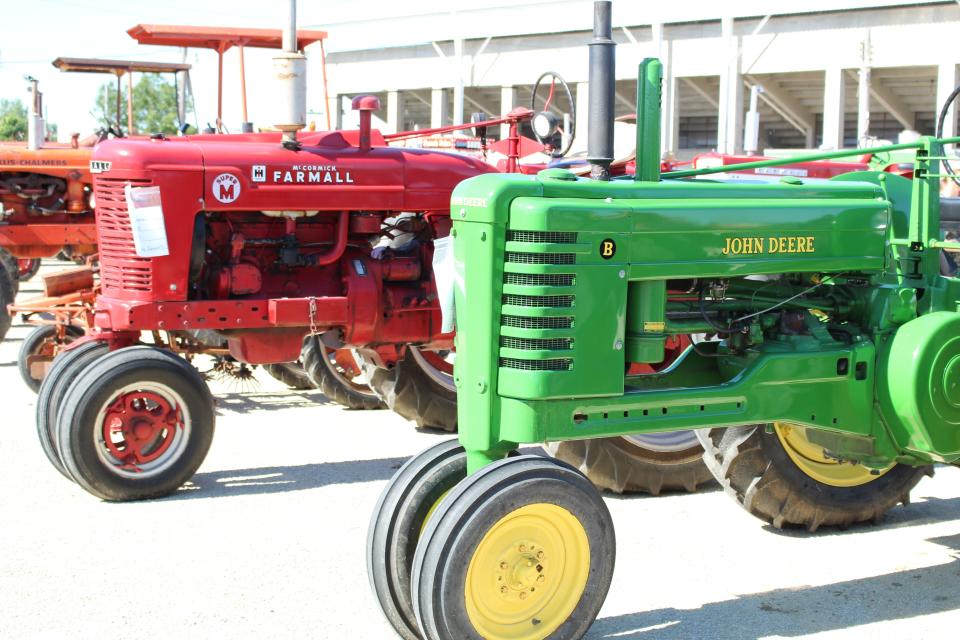 A 1951 M Farmall and a 1951 John Deere are displayed at the Crawford Farm Machinery Show at the Crawford County Fairgrounds on Friday evening.