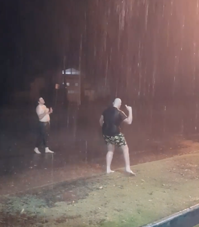 Men dance in the rain in Bourke, NSW, as rain is dumped on the state Saturday night and Sunday amid horrible drought conditions. 