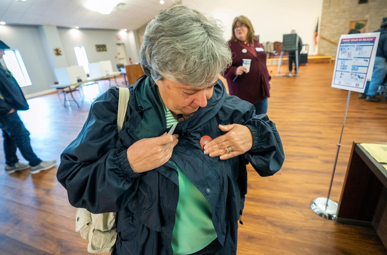 Paula McWilliams applies her "I Voted" sticker after casting her ballot Tuesday at the Union Township Hall in Hebron. McWilliams said she has voted in every election for the past 51 years, starting when she was 17 years old and was legally able to vote in the presidential election that year.