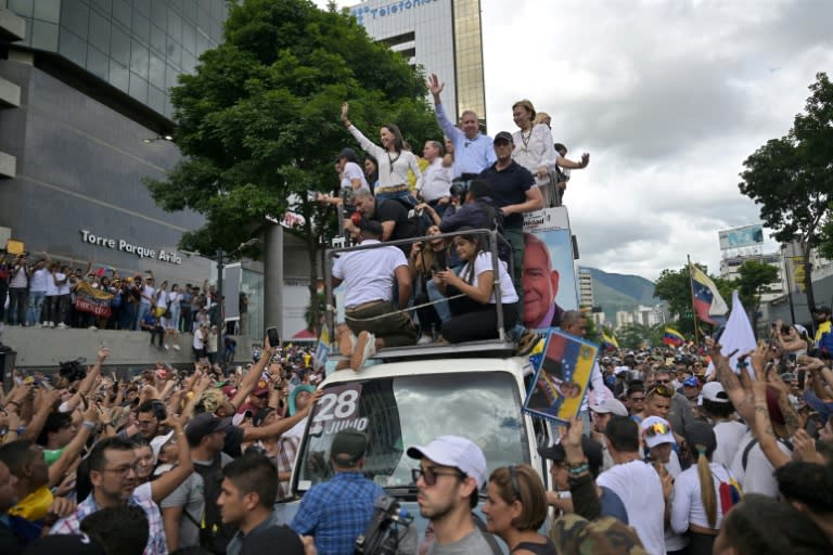 La líder opositora venezolana María Corina Machado y el candidato presidencial Edmundo González Urrutia (centro-derecha) saludan a sus partidarios durante una manifestación frente a la sede de las Naciones Unidas en Caracas el 30 de julio de 2024 (Juan BARRETO)