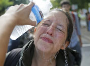 <p>A counter demonstrator gets a splash of water after being hit by pepper spray at the entrance to Lee Park in Charlottesville, Va., Saturday, Aug. 12, 2017. (Photo: Steve Helber/AP) </p>