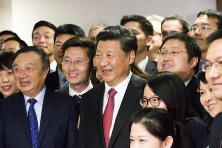 Chinese President Xi Jinping (C) poses for a photograph with Ren Zhengfei, president of Huawei Technologies Co Ltd, (L) and employees of Huawei at their offices in London, Britain October 21, 2015. REUTERS/Matthew Lloyd/Pool