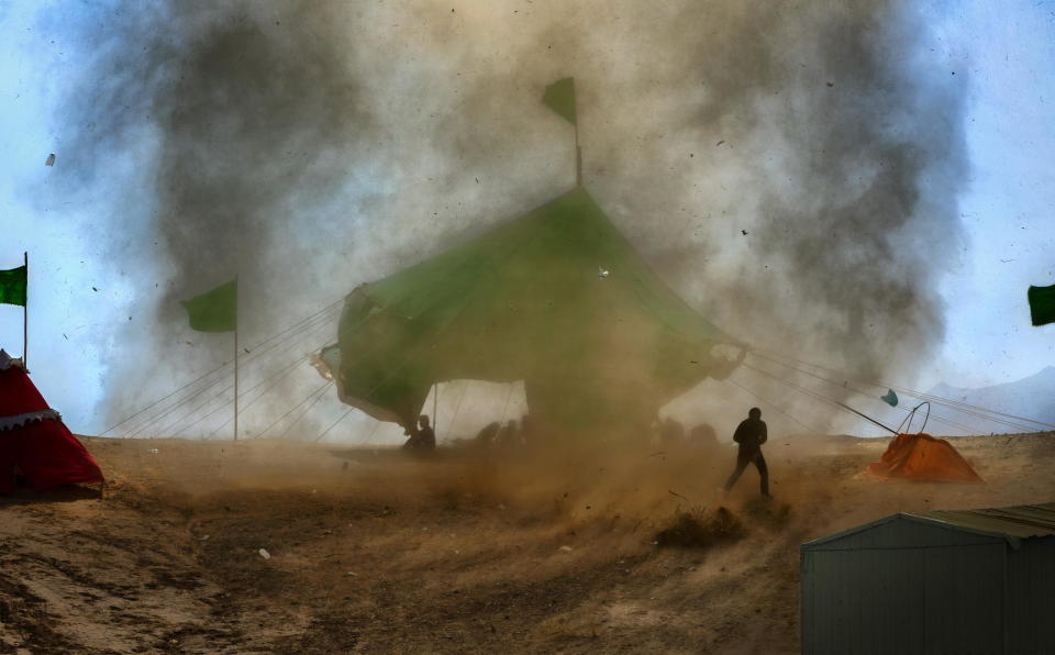 A small tornado appraoches a mourning ceremony site in Iran