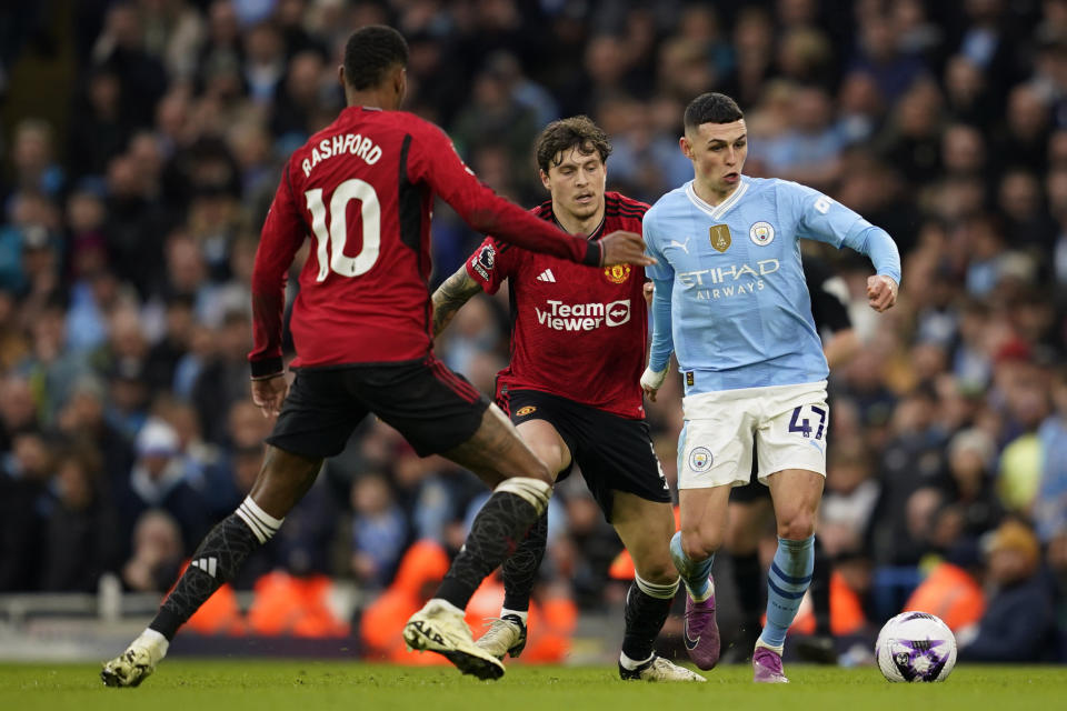 Manchester City's Phil Foden, right, controls the ball the ball as Manchester United's Marcus Rashford, left and Victor Lindelof challenge during an English Premier League soccer match between Manchester City and Manchester United at the Etihad Stadium in Manchester, England, Sunday, March 3, 2024. (AP Photo/Dave Thompson)