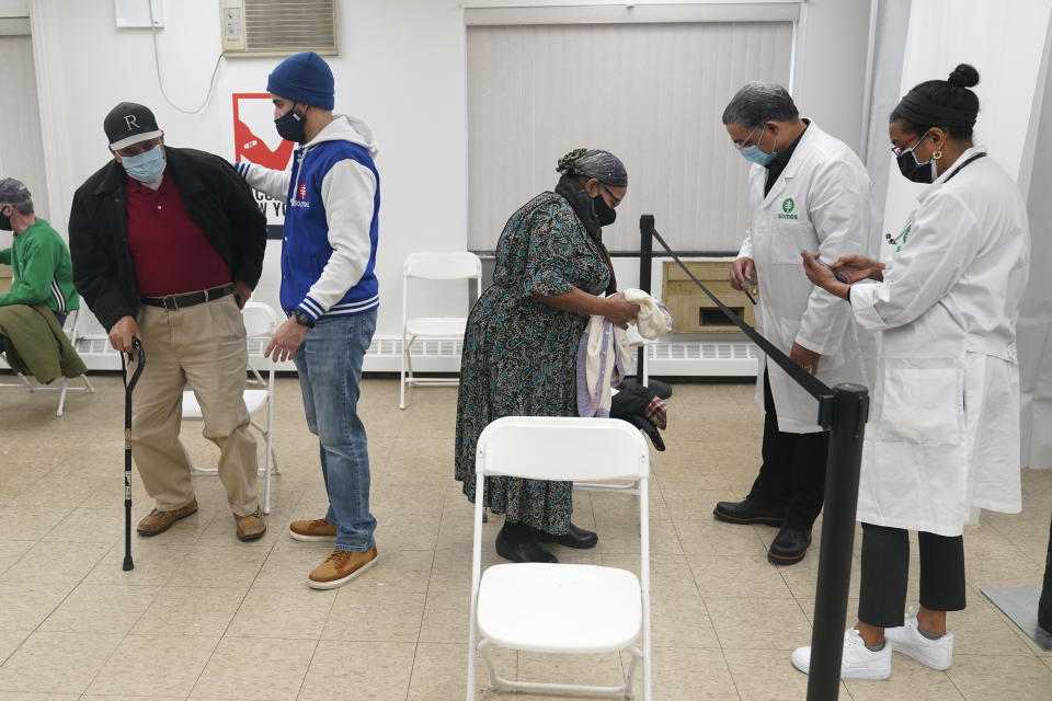 Dr. Ingrid Felix-Peralta, right, and her husband Dr. Victor Peralta, second from right, say goodbye to Roque Peralta, left, and Crila Rodriguez Peralta, center, (no relation) after Roque and Crila received their second doses of the COVID-19 vaccine in New York, Friday, Feb. 5, 2021. From elderly Cuban Americans in Florida to farmworkers in California, Latinos face daunting barriers like fear, language and a lack of education and access as the COVID-19 vaccines roll out, creating risks for public health as the virus mutates and spreads. (AP Photo/Seth Wenig)