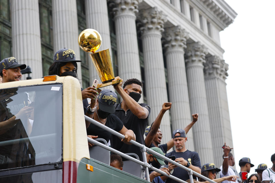 Milwaukee Bucks' Giannis Antetokounmpo holds up the NBA Championship trophy during a parade and celebration for the basketball team Thursday, July 22, 2021, in Milwaukee. (AP Photo/Jeffrey Phelps)