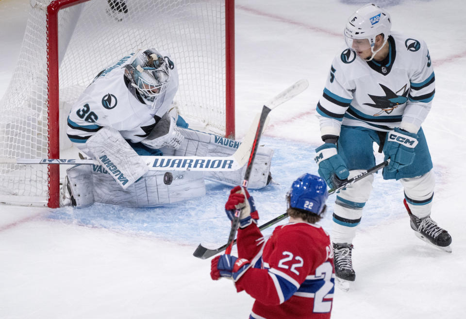 San Jose Sharks goaltender Kaapo Kahkonen makes a save against Montreal Canadiens' Cole Caufield as Sharks defenseman Matt Benning watches during the first period of an NHL hockey game Tuesday, Nov. 29, 2022, in Montreal. (Paul Chiasson/The Canadian Press via AP)