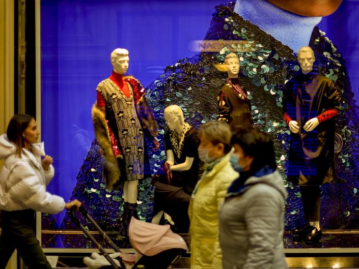 People walking past a Prada window at luxury mall GUM in Moscow, Russia.