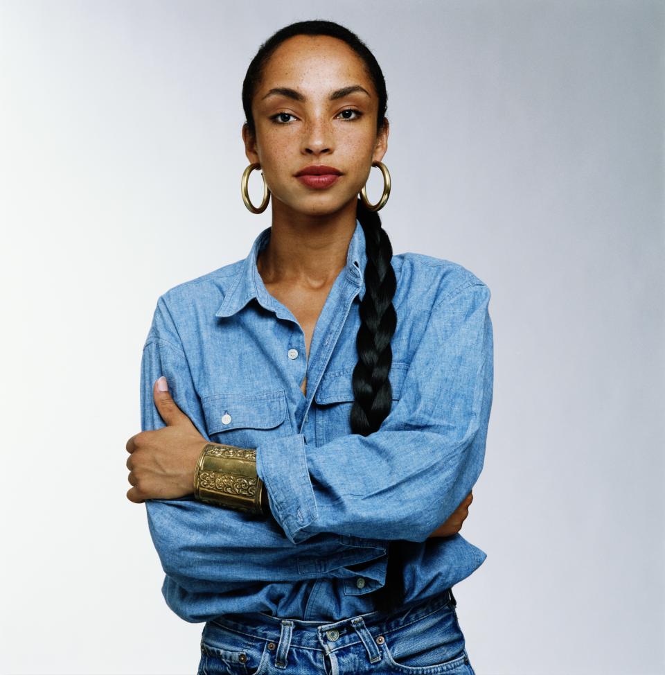 Sade knew how to rock a Canadian tuxedo. She keeps it classic with quite confidence, a red lip and perfect hoops.