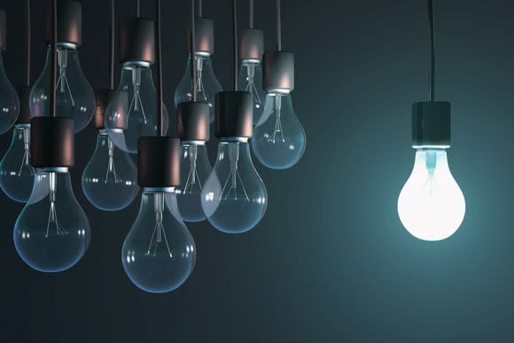 A single light bulb is turned on, while a cluster of nearby bulbs is turned off