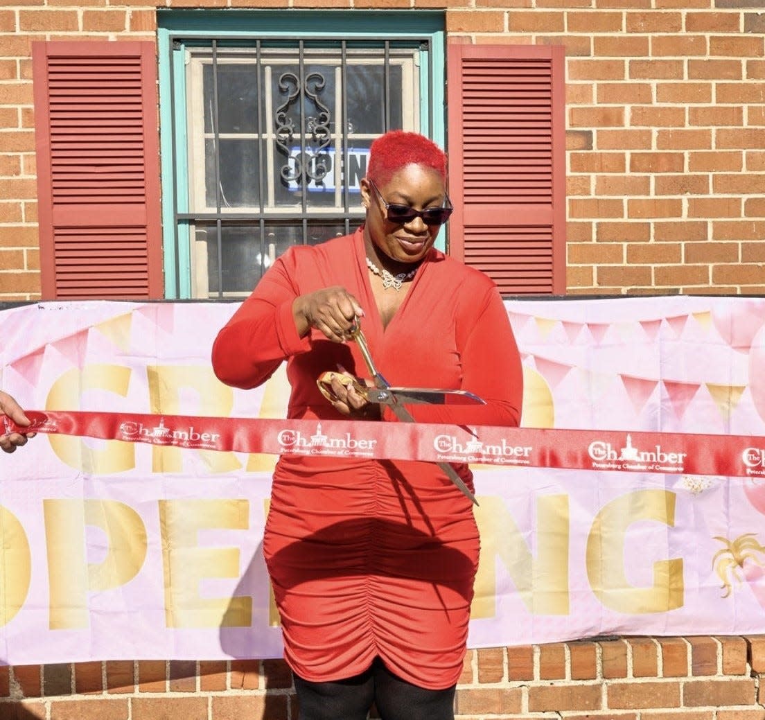 Beauti Curve Boutique owner Neshanta Harris cuts the ribbon at her grand opening in Petersburg on Feb. 1, 2024.