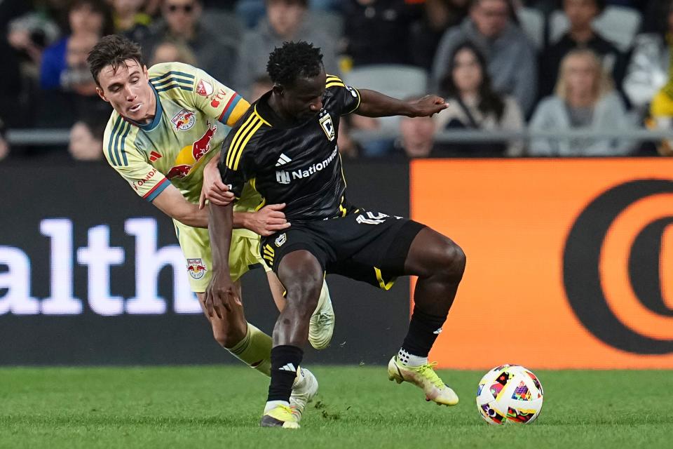 Mar 16, 2024; Columbus, Ohio, USA; Columbus Crew midfielder Yaw Yeboah (14) fights for the ball with New York Red Bulls midfielder Peter Stroud (5) during the first half of the MLS soccer match at Lower.com Field. Mandatory Credit: Adam Cairns-USA TODAY Sports