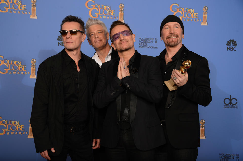 De izquierda a derecha, Larry Mullen Jr., Adam Clayton, Bono y The Edge de U2 posan tras ganar el Globo de Oro a la mejor canción original por "Ordinary Love", de la película "Mandela: Long Walk to Freedom", el domingo 12 de enero del 2014 en el hotel Beverly Hilton en Beverly Hills, California. (Foto por Jordan Strauss/Invision/AP)