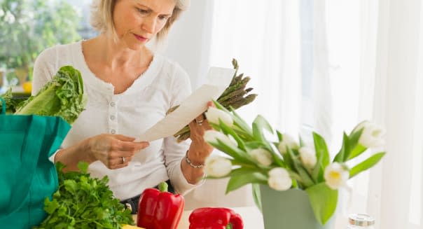 USA, New Jersey, Jersey City, Portrait of senior woman with shopping bag in kitchen