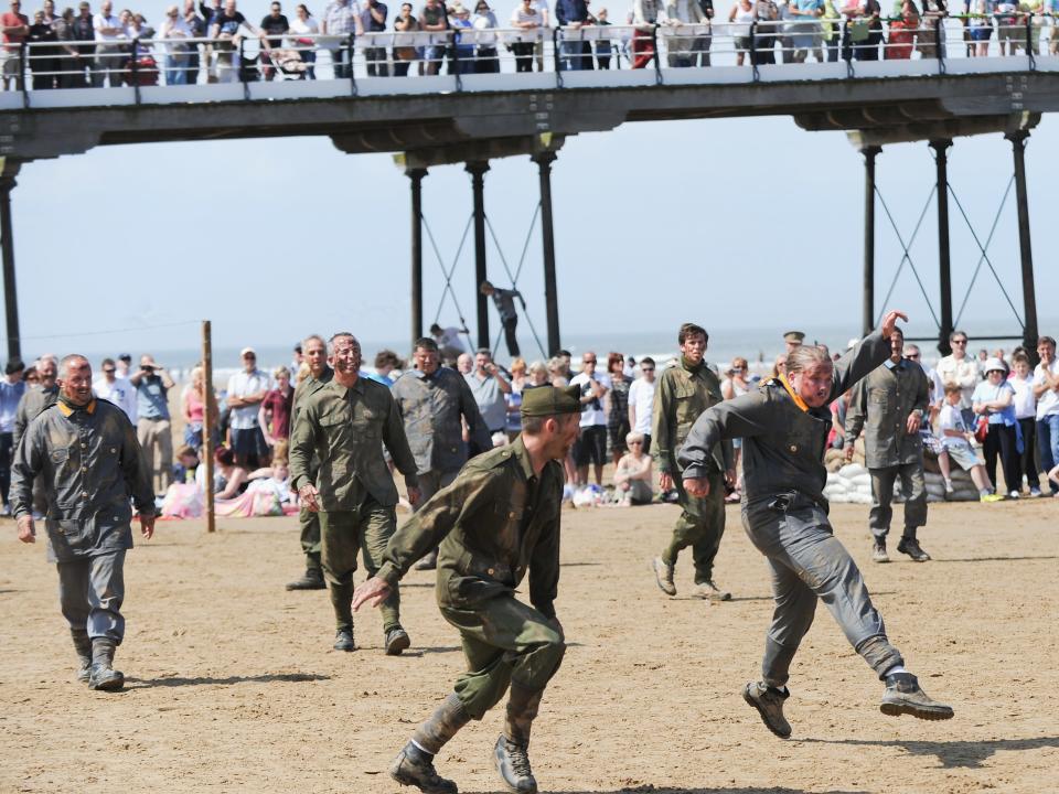 e-encators playing the British and German armies play football during a commemoration event to remember the World War one truce football match on June 1, 2014 in Saltburn-by-the-Sea, England.